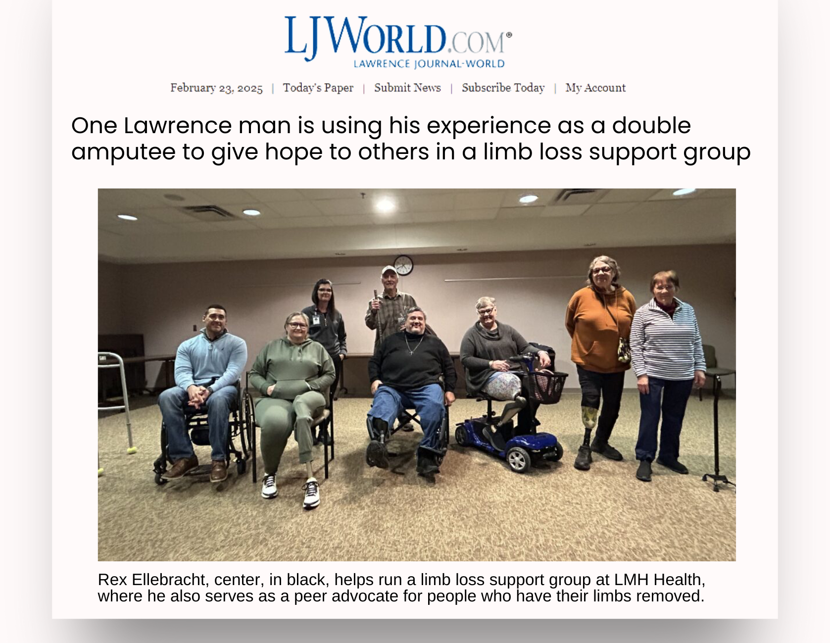 Photo of several people with limb loss in a conference room setting posing for a group photo