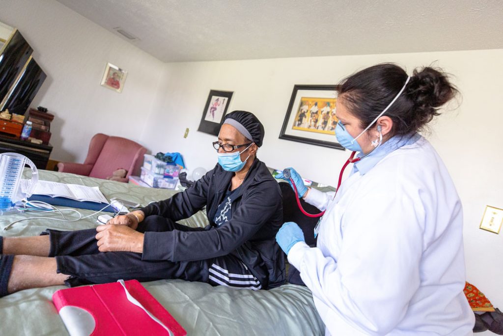 consumer in a home setting receiving home health care wearing masks, gloves and other protective gear during the COVID pandemic
