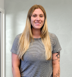 Female with dark blonde hair smiling at the camera