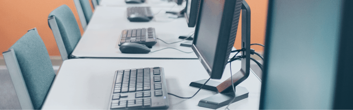 Photograph of a long gray desktop lined with computers
